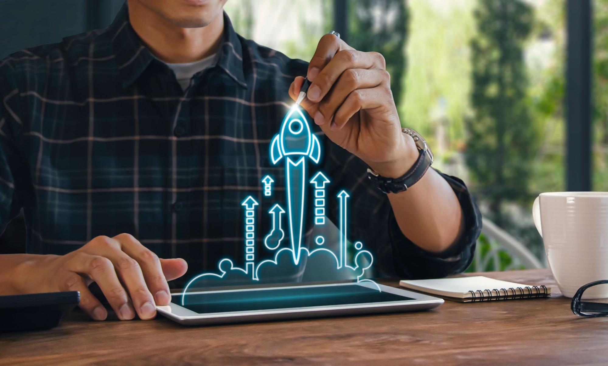 homem segurando tablet com holograma de foguete.